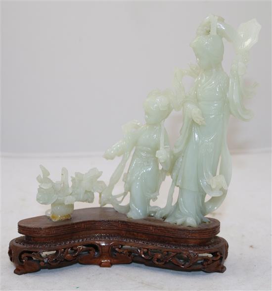 A Chinese pale celadon jade group of a lady and a girl with flowing robes, a basket beside them, 20th century, total height 19cm